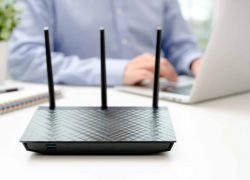 bigstock-Wireless-Router-And-Man-Using-211482115-scaled